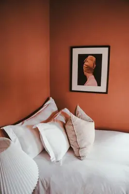 a bed with white pillows and a picture on the wall at No 3 at The Barracks in Stellenbosch