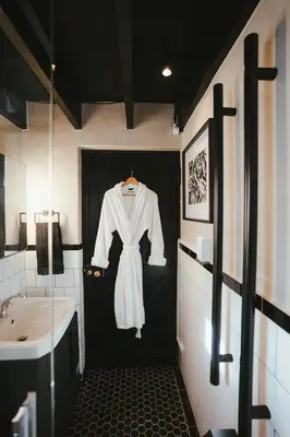 a white robe hanging on a door in a bathroom at No 3 at The Barracks in Stellenbosch
