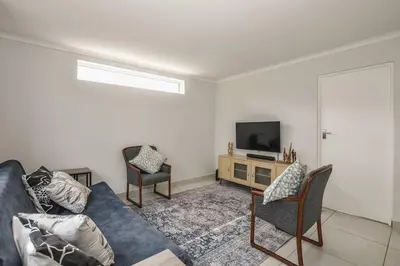 a living room with a couch and two chairs and a television at Pet friendly & Close to Beach at 2 Saasveld in Bloubergstrand