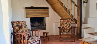 a living room with two chairs and a fireplace at Whipstock Guest Farm in McGregor