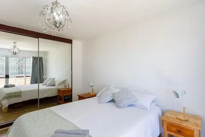 a bedroom with two beds and a chandelier at Ocean View B104 by CTHA in Bloubergstrand