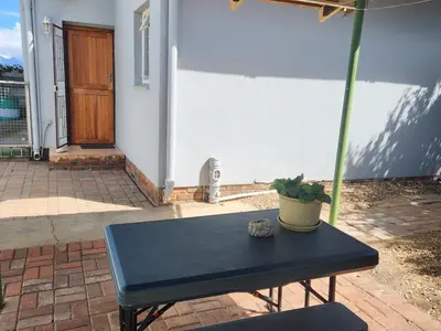 a black bench in front of a house with a plant at HartebeesDen in Worcester