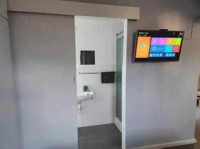 a bathroom with a sink and a tv on a wall at HartebeesDen in Worcester