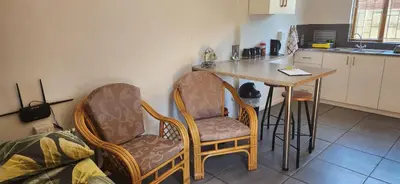 a kitchen with two chairs and a table and a counter at HartebeesDen in Worcester