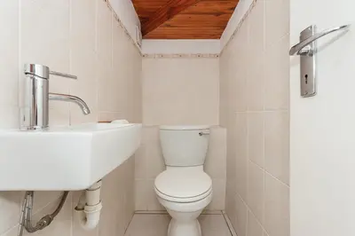 a bathroom with a white toilet and a sink at Secured 3-Bedroom Townhouse in Cape Town