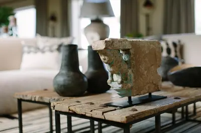 a wooden table with vases on it in a living room at The Thatch House Boutique Hotel, Hermanus in Hermanus