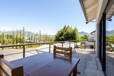 a wooden table on the balcony of a house at Pearl Valley Golf Estate Lodge 1E in Simondium