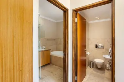 a bathroom with a tub and a toilet and a sink at Pearl Valley Golf Estate Lodge 1E in Simondium
