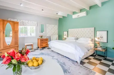 a bedroom with a bed and a bowl of fruit on a table at 1-Bed Cottage ,Sleeps 3, Walk to Boys High and Bossa in Paarl