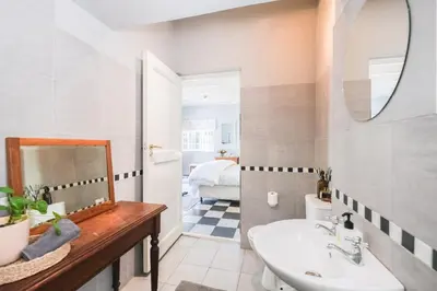 a bathroom with a sink and a mirror at 1-Bed Cottage ,Sleeps 3, Walk to Boys High and Bossa in Paarl