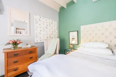 a bedroom with a bed and a dresser with a mirror at 1-Bed Cottage ,Sleeps 3, Walk to Boys High and Bossa in Paarl