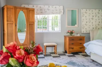 a bedroom with a bed and a mirror and a dresser at 1-Bed Cottage ,Sleeps 3, Walk to Boys High and Bossa in Paarl