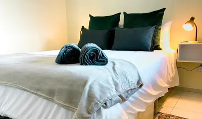 a bedroom with a large bed with blue pillows at Beachside Escape in Cape Town
