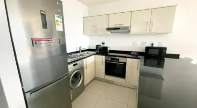 a kitchen with a stainless steel refrigerator and a dishwasher at Beachside Escape in Cape Town