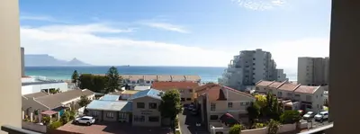 a view of a city with the ocean and buildings at Beachside Escape in Cape Town