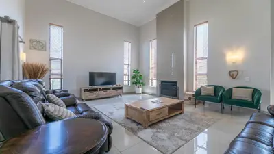 a living room with leather furniture and a tv at Paraiso - A cozy retreat , your home away from home in Cape Town