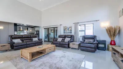 a living room with couches and chairs and a table at Paraiso - A cozy retreat , your home away from home in Cape Town