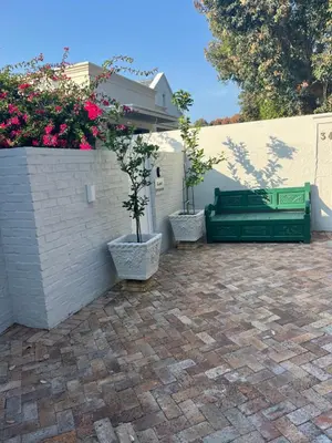 a patio with two potted trees and a fence at On Musson in Hermanus