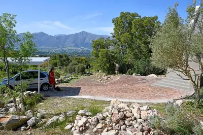 a woman standing next to a car on a hill at Stonehedge Cottages in Franschhoek