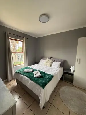 a bedroom with a bed with a green blanket on it at Boho Bliss in Cape Town