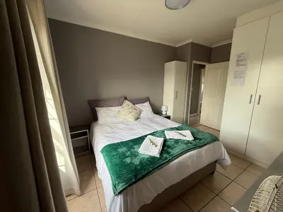 a bedroom with a bed with two towels on it at Boho Bliss in Cape Town