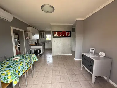 a living room with a table and a kitchen at Boho Bliss in Cape Town
