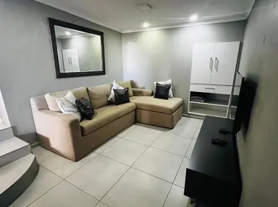 a living room with a couch and a mirror at Boho Bliss in Cape Town