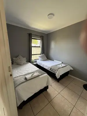 two beds in a room with a window at Boho Bliss in Cape Town