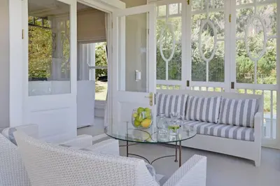 a living room with a couch and a glass table at Farm Lorraine The Loft Cottage in Franschhoek