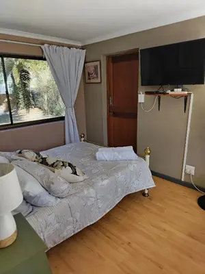 a bedroom with a dog laying on a bed at Rustig by die See in Bettyʼs Bay
