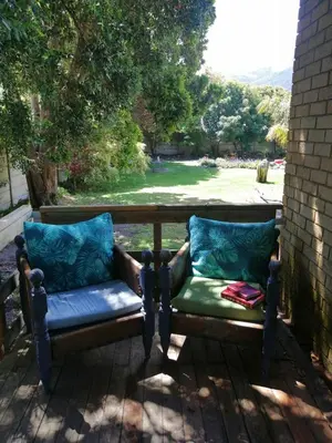 a pair of benches sitting on a porch at Rustig by die See in Bettyʼs Bay