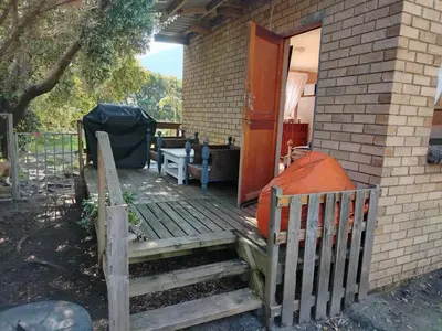 a porch with a wooden ramp leading to a house at Rustig by die See in Bettyʼs Bay