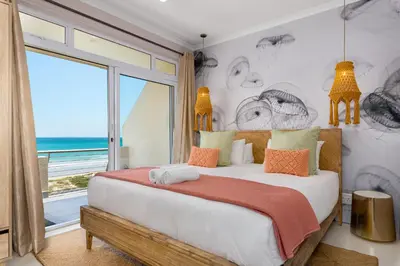 a bedroom with a bed with a view of the ocean at 323 Leisure Bay in Cape Town