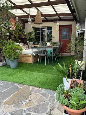 a patio with a table and chairs and plants at La Casetta, Garden Retreat in Cape Town