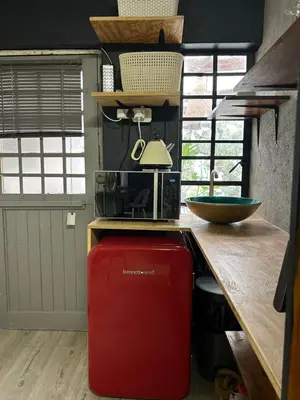 a kitchen with a red refrigerator under a counter at La Casetta, Garden Retreat in Cape Town