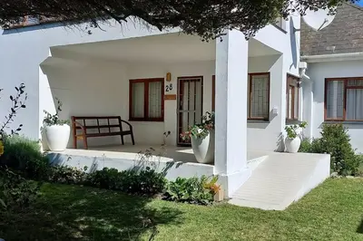 a porch of a white house with a bench at Mogit-ewig-duur in Hermanus