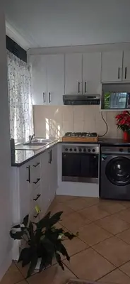 a kitchen with white cabinets and a stove top oven at V's Condo in Gordonʼs Bay
