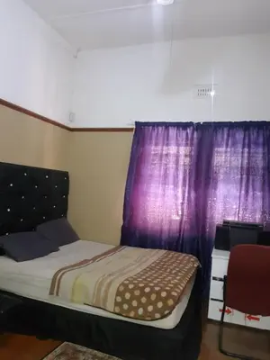 a bedroom with a bed and purple curtains at Room Parow, Cape Town in Cape Town