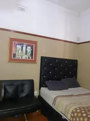 a bedroom with a bed with a black headboard at Room Parow, Cape Town in Cape Town