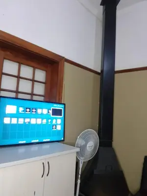 a room with a tv and a fan and a fan at Room Parow, Cape Town in Cape Town