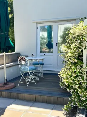 a patio with a table and chairs and a door at Charming Flatlet Near the Amazing Sunset Beach in Cape Town
