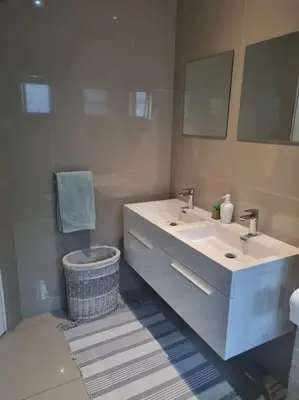 a bathroom with two sinks and a toilet and a mirror at A cozy retreat - feels like home in Cape Town