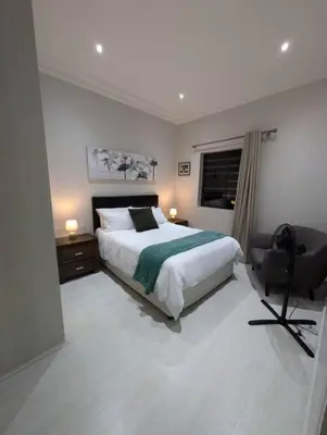 a bedroom with a bed and a desk and a chair at A cozy retreat - feels like home in Cape Town