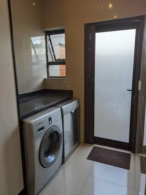 a laundry room with a washing machine and a window at A cozy retreat - feels like home in Cape Town