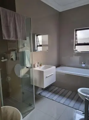 a bathroom with a shower and a sink and a tub at A cozy retreat - feels like home in Cape Town
