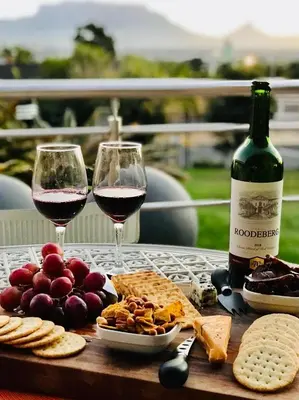 a table with two glasses of wine and cheese at Bonita Vista Plattekloof in Cape Town