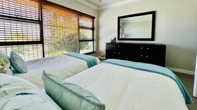 a bedroom with two beds and a mirror on the wall at Bonita Vista Plattekloof in Cape Town