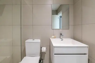 a bathroom with a white toilet and a sink at Top Floor Beachfront w Views, Blouberg, 51 Beach Break in Bloubergstrand