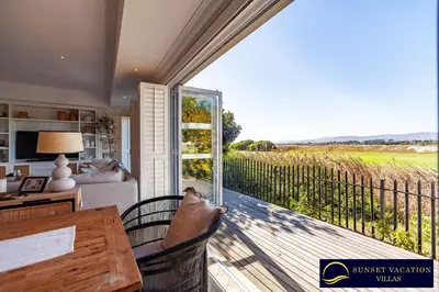 a person sitting on a chair on the balcony of a house at Sunsets Jasmine Villa in Cape Town
