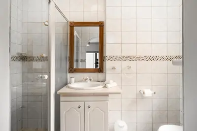 a bathroom with a sink and a shower with a mirror at En-suite Room, Walking distance to Kite Beach in Cape Town
